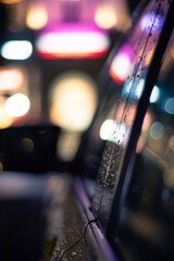 Reflections and bokeh of lights after rain on a car