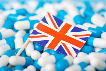 Pandemic in UK. Union Jack on pile of medical pills capsules