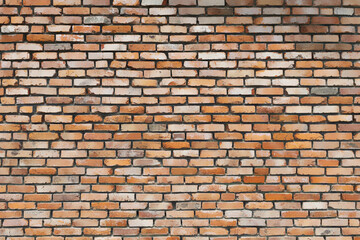 old brick wall from red bricks. non-uniform lighting. different shades of bricks