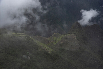 views of Macchu Picchu through the mist with clouds, Peru