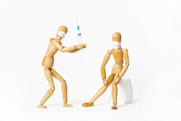 Wooden mannequins, on a white background. Vaccination.