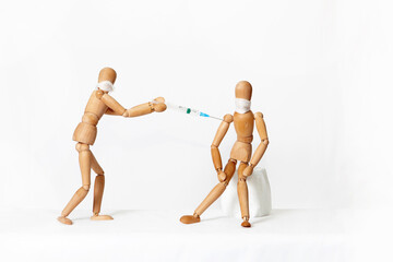 Wooden mannequins, on a white background. Vaccination.