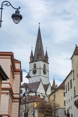 Fototapeta na wymiar Selective Focus. Clock Tower Of A Romanian City Called Sibiu And A Beautiful Sky. Sibiu City In Romania