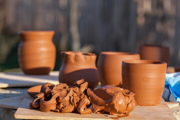 Close-up of clay products, after working on a potter's wheel, outdoors, selective focus.
Pots, dishes, clay pot
and other baked clay products.