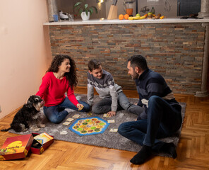 Family playing board game on floor