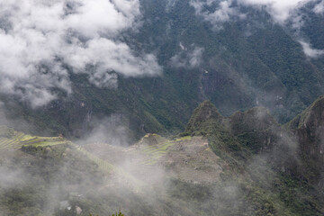 Views of Macchu PIcchu amidst the clouds in Peru - obrazy, fototapety, plakaty