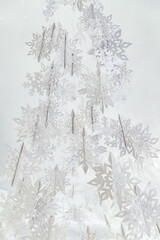 Fototapeta premium Decoration of paper white snowflakes in the form of a Christmas tree