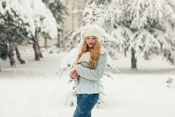 Fototapeta na wymiar Young beautiful blonde woman in a snowy forest