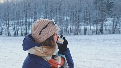 Fototapeta na wymiar Caucasian Female Traveller Tourist Warming Up Drinking Hot Drink from Vacuum Flask Thermos during Cold Winter Morning Mountain Forest Hike Closeup