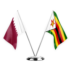 Two table flags isolated on white background 3d illustration, qatar and zimbabwe