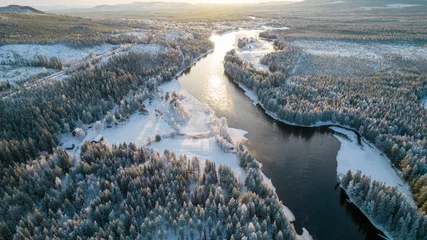 Foto op Aluminium Aerial view of snowy winter forest with black river. Drone photography - panoramic image of beautiful frosty trees and loops of river in Jamtland County, Sweden © boumenjapet
