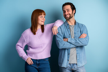 Fototapeta premium Young pretty couple isolated on blue background. Youth, hipster style, students, friends together