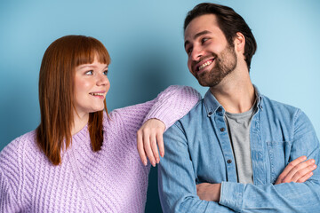 Fototapeta premium Two cheerful male and female persons standing close to each other
