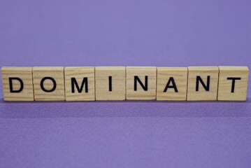 word dominant in small wooden letters with lilac background