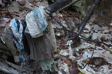 coloured old cloths along the stream contaminating the water - envirinmental pollution