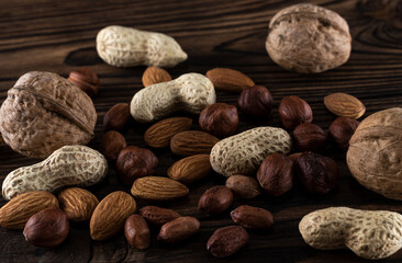 Appetizing and useful different nuts on a wooden background
