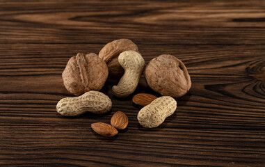 Appetizing and useful different nuts on a wooden background.