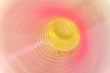 Pink and yellow slinky walking spring toy detail, pastel plastic spiral abstract background	