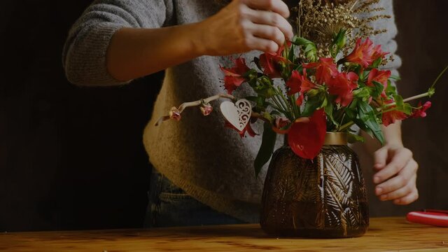 Valentines day flower arrangement, festive DIY home decor. Florist makes bouquet of flowers for Valentine's day. 
