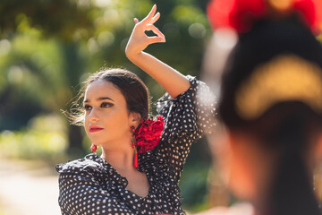 Fototapeta premium Selective focus on a beauty hispanic woman dancing flamenco in a park