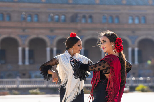 Two woman in flamenco dress dancing outdoors