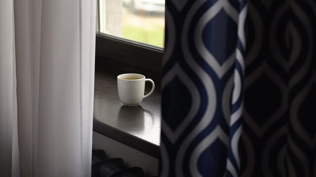 Loneliness of man sitting at home brightened up with cup of tea during lockdown