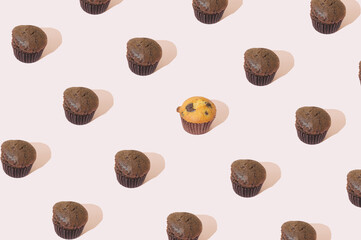 Chocolate brown muffins on a pink background. Sweet food pattern aesthetic concept.
