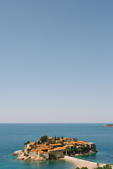 Fototapeta na wymiar Sveti Stefan Island against a blue sky in the Bay of Kotor