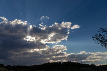 Beautiful clouds covering the sun, projecting beautiful rays of light. Space for text.