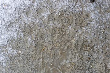 macro photo of crunchy ice and snow frozen on a dirty and grunge concrete sidewalk