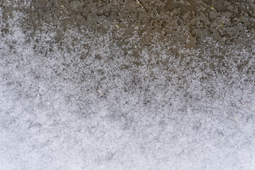 macro photo of crunchy ice and snow frozen on a dirty and grunge concrete sidewalk