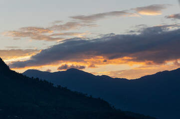 Light coming through window of clouds from setting sun, over Himalayan Mountain peaks. Dramatic cloud formation - Himalaya, India.