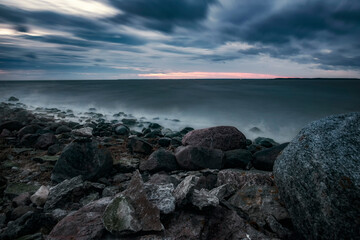 mystical foggy sea and rocky shore in the evening