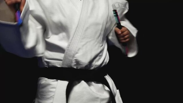 Man in white karate uniform practices with bladed weapons known as kamas, martial arts lifestyle, weapons training concept