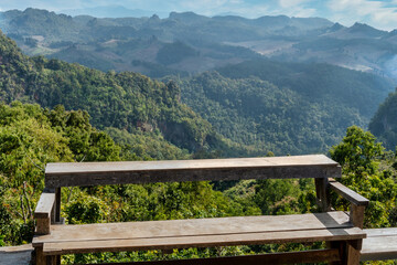 a wooden bench and View of Mountains from Ban Jabo Village in Northern Thailand