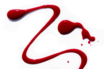 Attractive abstract background: spilled red nail polish, a few strokes and drops