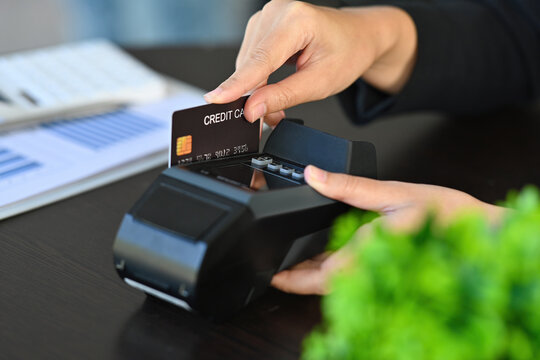 Cropped image of customer's hand doing payment by using a credit card at the credit card reader.