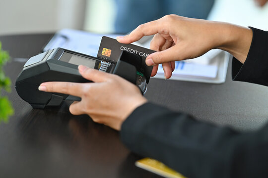 Cropped image of customer's hand doing payment by using a credit card at the credit card reader.
