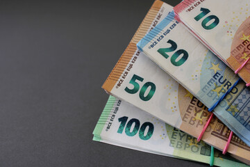 Stacks of 10, 20, 50 and 100 euro banknotes, tied with rubber band and fixed in the form of a fan,...