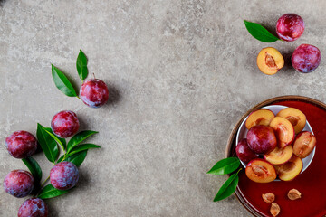 Top view of plate with ripe and halves red plum.