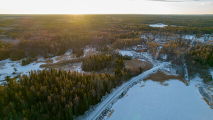 Aerial view of little Swedish village with islands and forests on a Baltic sea coast at winter time. Drone photography - winter in Gavleborg County, Axmar Burk Sweden