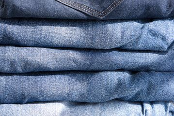 pile of blue jeans on a light background. Close up