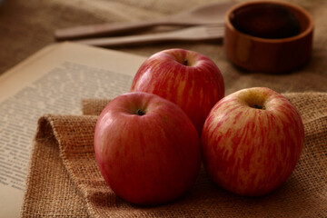Three apple placed on an old book 