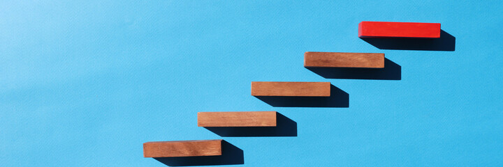 Wooden blocks in form of ladder upstairs red on dove background