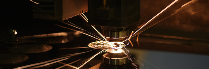 Sparks from automatic laser cutting or engraving of parts closeup