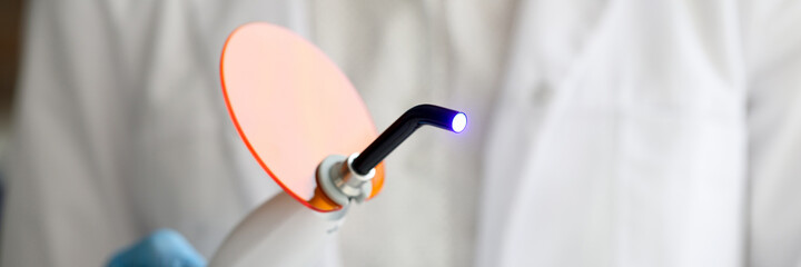 Dental UV polymerization lamp and artificial jaw model. UV lamp closeup