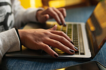 Close up de manos de mujer trabajando en laptop desde casa