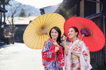 Asian woman tourists. Two Beautiful girl wearing traditional japanese kimono in popular in Old...