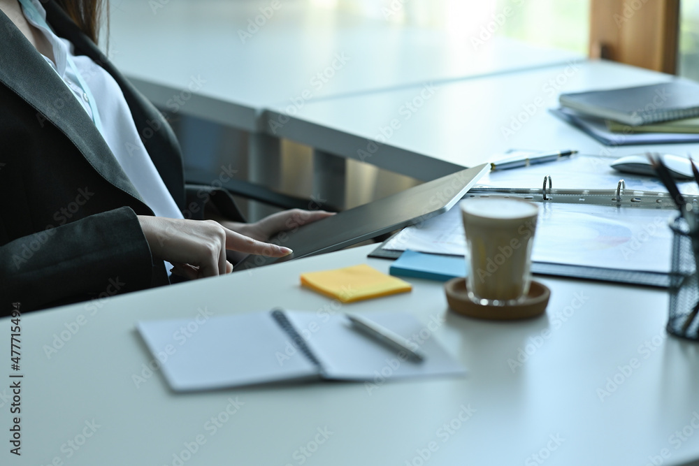 Poster cropped image of a female reception using a digital tablet at the modern reception counter.