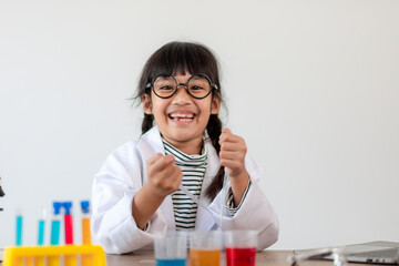 education, science, chemistry and children concept - kids or students with test tube making experiment at school laboratory